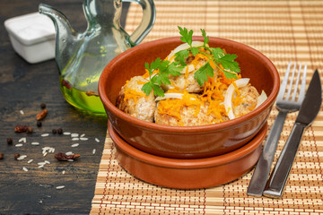 Fresh hot just cooked meatballs in the rustic brown ball on the natural wooden background. Healthy nutrition concept.