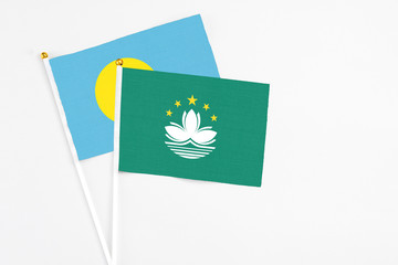 Macao and Palau stick flags on white background. High quality fabric, miniature national flag. Peaceful global concept.White floor for copy space.