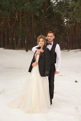 Naklejka premium the couple is hugging and close to the kiss, holding hands, a bouquet in their hands. A suit with a butterfly and a coat with a dress. The bride and the groom