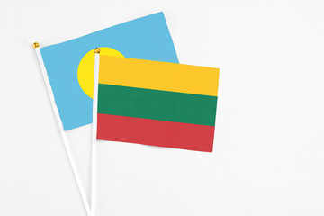 Lithuania and Palau stick flags on white background. High quality fabric, miniature national flag. Peaceful global concept.White floor for copy space.