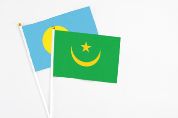 Mauritania and Palau stick flags on white background. High quality fabric, miniature national flag. Peaceful global concept.White floor for copy space.