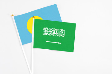 Saudi Arabia and Palau stick flags on white background. High quality fabric, miniature national flag. Peaceful global concept.White floor for copy space.