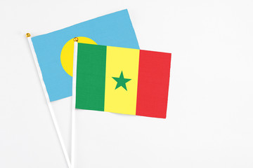 Senegal and Palau stick flags on white background. High quality fabric, miniature national flag. Peaceful global concept.White floor for copy space.