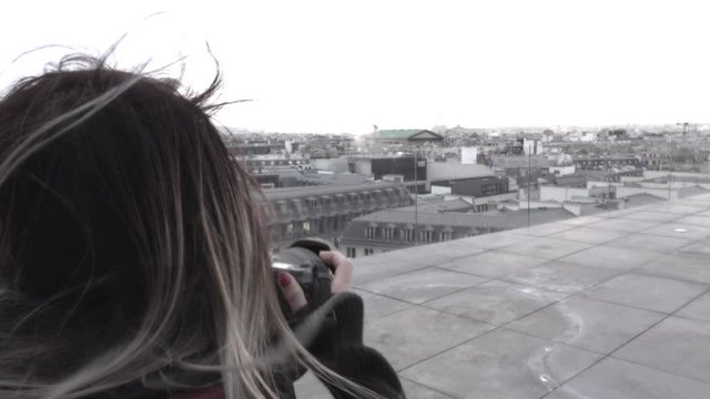 Back view of young  woman photographer taking picture on the roof with eiffel tower ,paris france,soft black and white tone