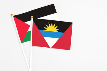 Antigua and Barbuda and Palestine stick flags on white background. High quality fabric, miniature national flag. Peaceful global concept.White floor for copy space.
