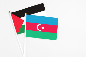 Azerbaijan and Palestine stick flags on white background. High quality fabric, miniature national flag. Peaceful global concept.White floor for copy space.