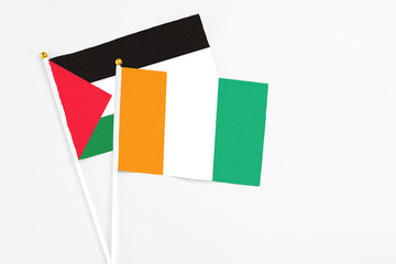 Cote D'Ivoire and Palestine stick flags on white background. High quality fabric, miniature...
