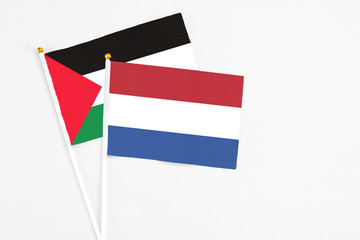 Netherlands and Palestine stick flags on white background. High quality fabric, miniature national...