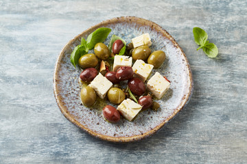 Green and kalamata olives, capers and feta cheese on rustic wooden background. Healthy Snack Idea. Close up. 