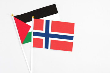 Norway and Palestine stick flags on white background. High quality fabric, miniature national flag. Peaceful global concept.White floor for copy space.
