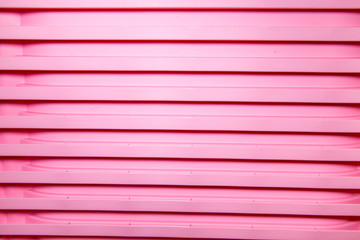 Vertical bright stripes of plastic basins stacked in a pile of pink. Abstraction, structures,...