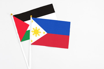 Philippines and Palestine stick flags on white background. High quality fabric, miniature national...