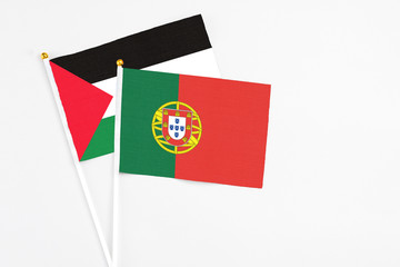 Portugal and Palestine stick flags on white background. High quality fabric, miniature national flag. Peaceful global concept.White floor for copy space.