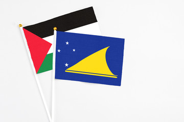 Tokelau and Palestine stick flags on white background. High quality fabric, miniature national flag. Peaceful global concept.White floor for copy space.