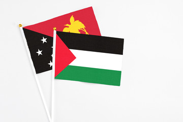 Palestine and Papua New Guinea stick flags on white background. High quality fabric, miniature national flag. Peaceful global concept.White floor for copy space.