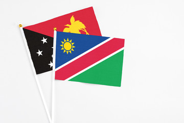 Namibia and Papua New Guinea stick flags on white background. High quality fabric, miniature national flag. Peaceful global concept.White floor for copy space.