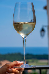 glass of white wine on the beach with blue background