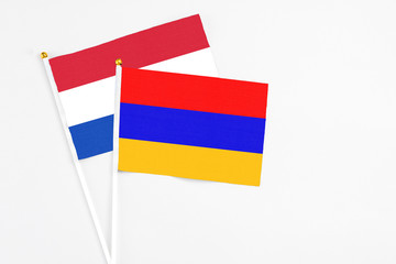 Armenia and Paraguay stick flags on white background. High quality fabric, miniature national flag. Peaceful global concept.White floor for copy space.