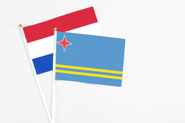 Aruba and Paraguay stick flags on white background. High quality fabric, miniature national flag. Peaceful global concept.White floor for copy space.