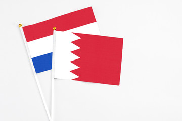 Bahrain and Paraguay stick flags on white background. High quality fabric, miniature national flag. Peaceful global concept.White floor for copy space.