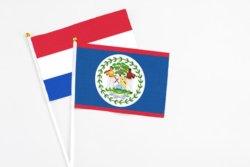 Belize and Paraguay stick flags on white background. High quality fabric, miniature national flag. Peaceful global concept.White floor for copy space.
