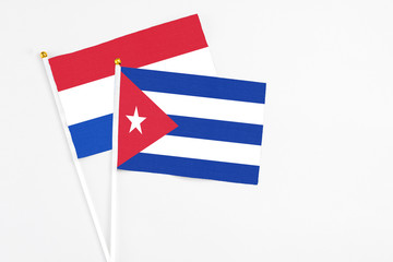 Cuba and Paraguay stick flags on white background. High quality fabric, miniature national flag. Peaceful global concept.White floor for copy space.