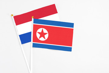 North Korea and Paraguay stick flags on white background. High quality fabric, miniature national flag. Peaceful global concept.White floor for copy space.