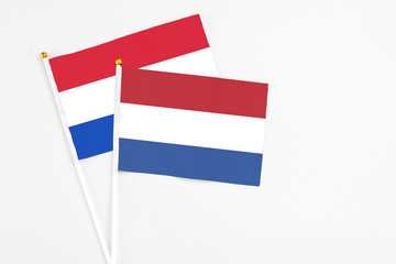 Netherlands and Paraguay stick flags on white background. High quality fabric, miniature national flag. Peaceful global concept.White floor for copy space.