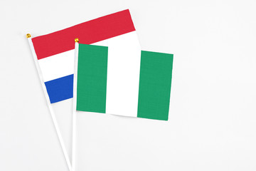 Nigeria and Paraguay stick flags on white background. High quality fabric, miniature national flag. Peaceful global concept.White floor for copy space.