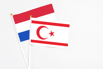 Northern Cyprus and Paraguay stick flags on white background. High quality fabric, miniature national flag. Peaceful global concept.White floor for copy space.