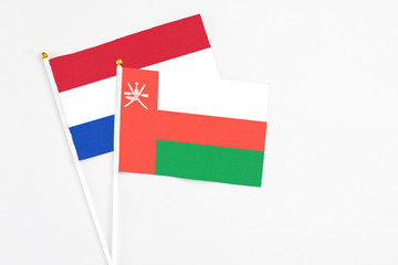 Oman and Paraguay stick flags on white background. High quality fabric, miniature national flag. Peaceful global concept.White floor for copy space.