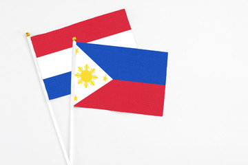 Philippines and Paraguay stick flags on white background. High quality fabric, miniature national flag. Peaceful global concept.White floor for copy space.