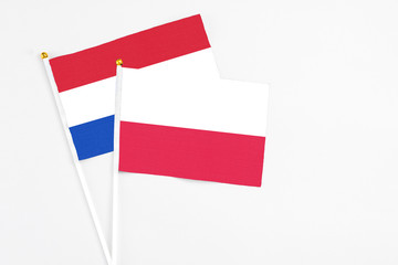 Poland and Paraguay stick flags on white background. High quality fabric, miniature national flag. Peaceful global concept.White floor for copy space.