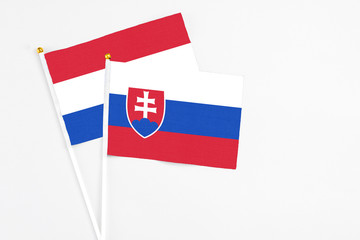 Slovakia and Paraguay stick flags on white background. High quality fabric, miniature national flag. Peaceful global concept.White floor for copy space.