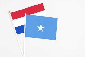 Somalia and Paraguay stick flags on white background. High quality fabric, miniature national flag. Peaceful global concept.White floor for copy space.