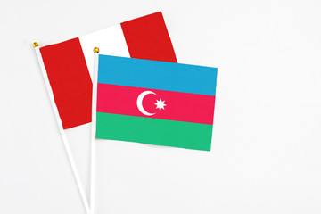 Azerbaijan and Peru stick flags on white background. High quality fabric, miniature national flag. Peaceful global concept.White floor for copy space.