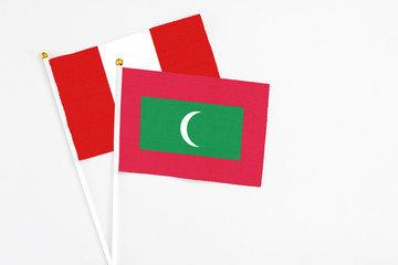 Maldives and Peru stick flags on white background. High quality fabric, miniature national flag. Peaceful global concept.White floor for copy space.