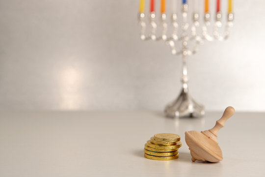 concept of of jewish religious holiday hanukkah with wooden spinning top toy (dreidel) and chocolate coins