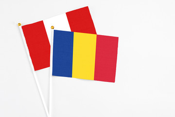Romania and Peru stick flags on white background. High quality fabric, miniature national flag. Peaceful global concept.White floor for copy space.