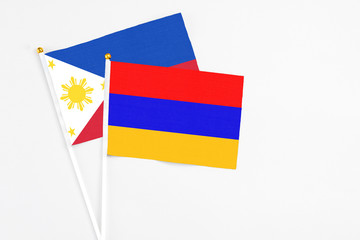 Armenia and Philippines stick flags on white background. High quality fabric, miniature national flag. Peaceful global concept.White floor for copy space.