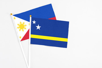 Curacao and Philippines stick flags on white background. High quality fabric, miniature national flag. Peaceful global concept.White floor for copy space.