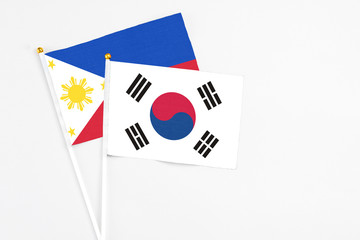 South Korea and Philippines stick flags on white background. High quality fabric, miniature national flag. Peaceful global concept.White floor for copy space.