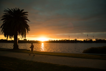 Man walking by the lake at sunset