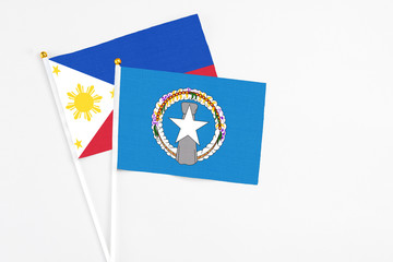 Northern Mariana Islands and Philippines stick flags on white background. High quality fabric, miniature national flag. Peaceful global concept.White floor for copy space.