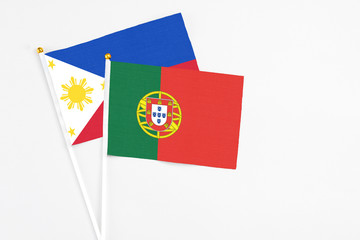 Portugal and Philippines stick flags on white background. High quality fabric, miniature national flag. Peaceful global concept.White floor for copy space.