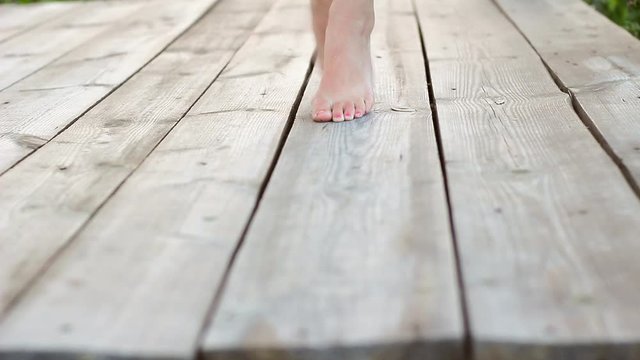 Close Up Bare Feet Of Girl Walking On Tiptoes On Old Wooden Floor Outdoors