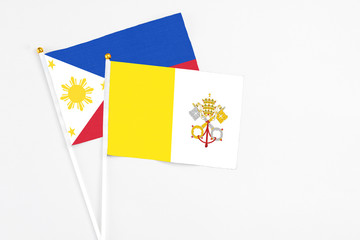 Vatican City and Philippines stick flags on white background. High quality fabric, miniature national flag. Peaceful global concept.White floor for copy space.