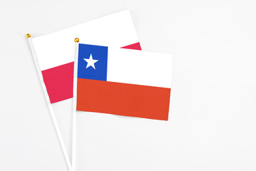 Chile and Poland stick flags on white background. High quality fabric, miniature national flag. Peaceful global concept.White floor for copy space.