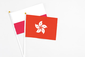 Hong Kong and Poland stick flags on white background. High quality fabric, miniature national flag. Peaceful global concept.White floor for copy space.