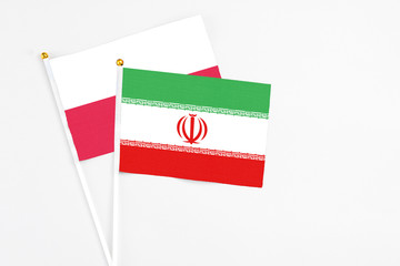 Iran and Poland stick flags on white background. High quality fabric, miniature national flag. Peaceful global concept.White floor for copy space.